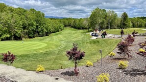A golf course with a well-maintained green, surrounded by trees and a clear sky. - Direct Lakefront Connestee Falls: Views + private dock + 4 kayaks + Not steep! (Brevard)
