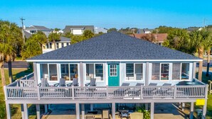 A two-story house with a balcony, multiple windows, and a door. - EdiStar at Edisto Beach (Edisto Beach)
