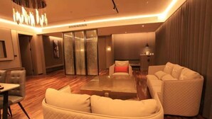 Una habitación de hotel moderna con una mesa de centro de vidrio, un sofá y una cama.