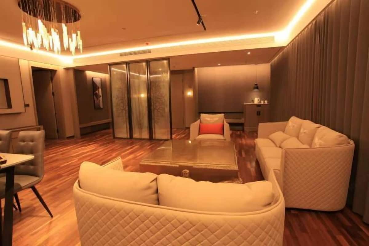 Una habitación de hotel moderna con una mesa de centro de vidrio, un sofá y una cama.