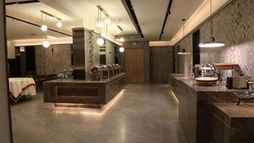 A hotel lobby with a reception desk, seating area, and a large mirror.