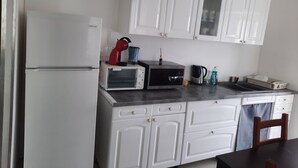 A compact kitchen with white cabinets, a microwave, a toaster, a kettle, and a sink. - beautiful apartment 150m2, 4 bedrooms, 6 people (Noidans-le-Ferroux)