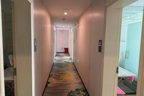 A hotel hallway with a carpeted floor, doors on both sides, and a visible bathroom on the right. - Dingsheng Express Hotel (Ningde)