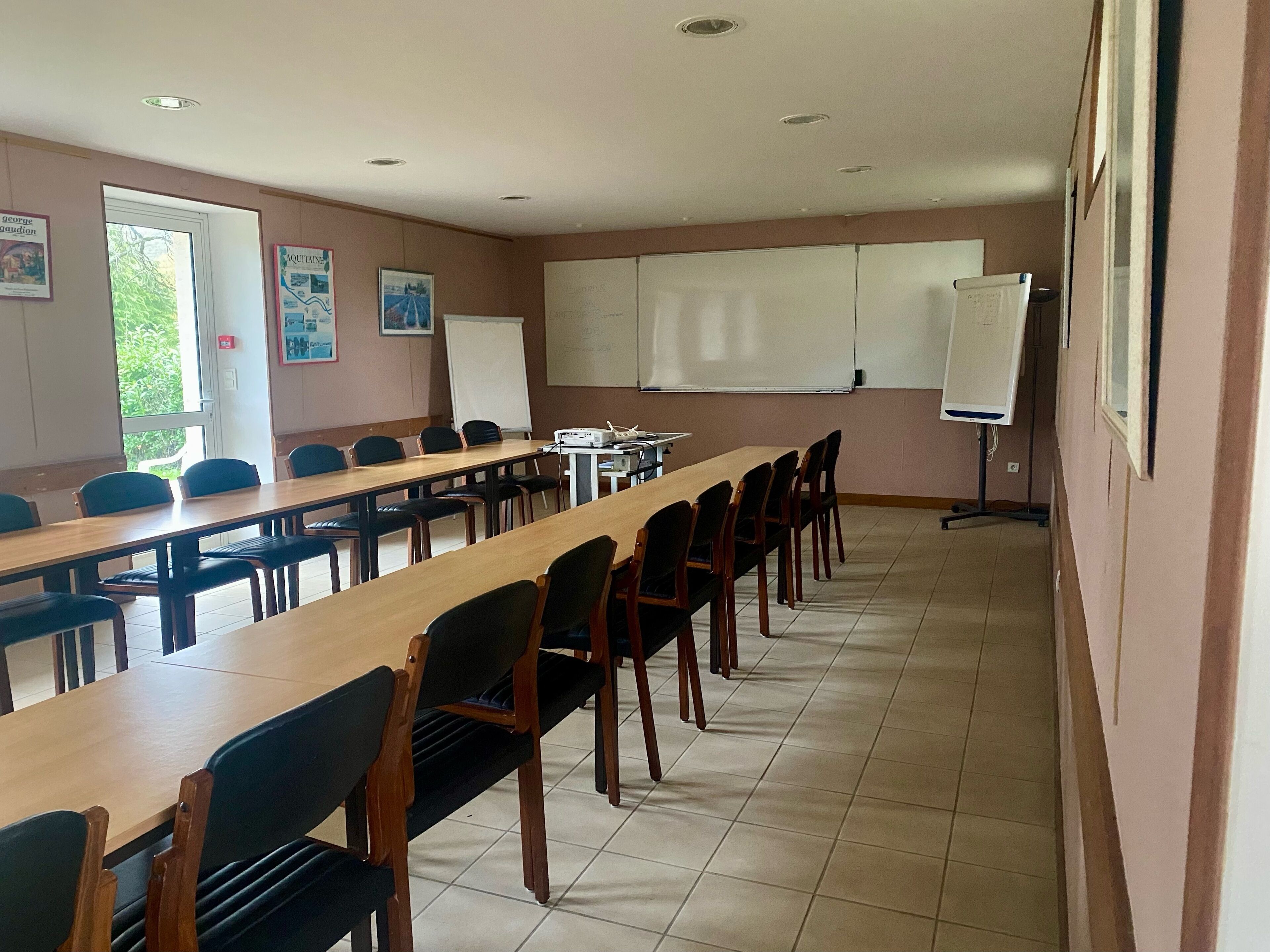 A conference room with a long table and chairs, a whiteboard, and a projector.