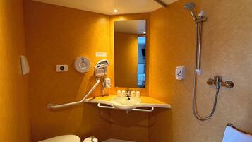 Un bagno compatto con il water, lavandino e doccia.