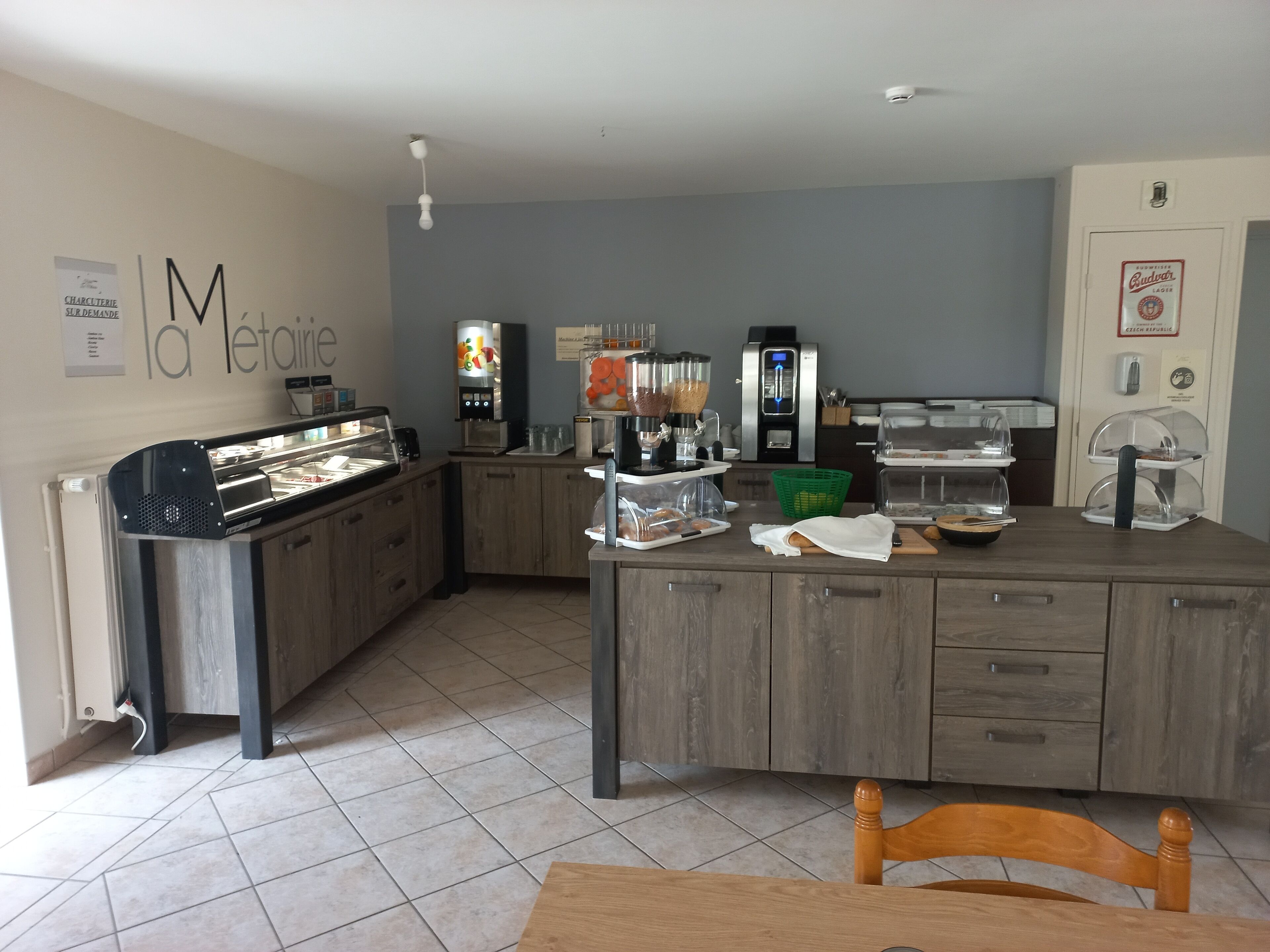 A café with a counter, coffee machines, and a seating area with a table and chairs.