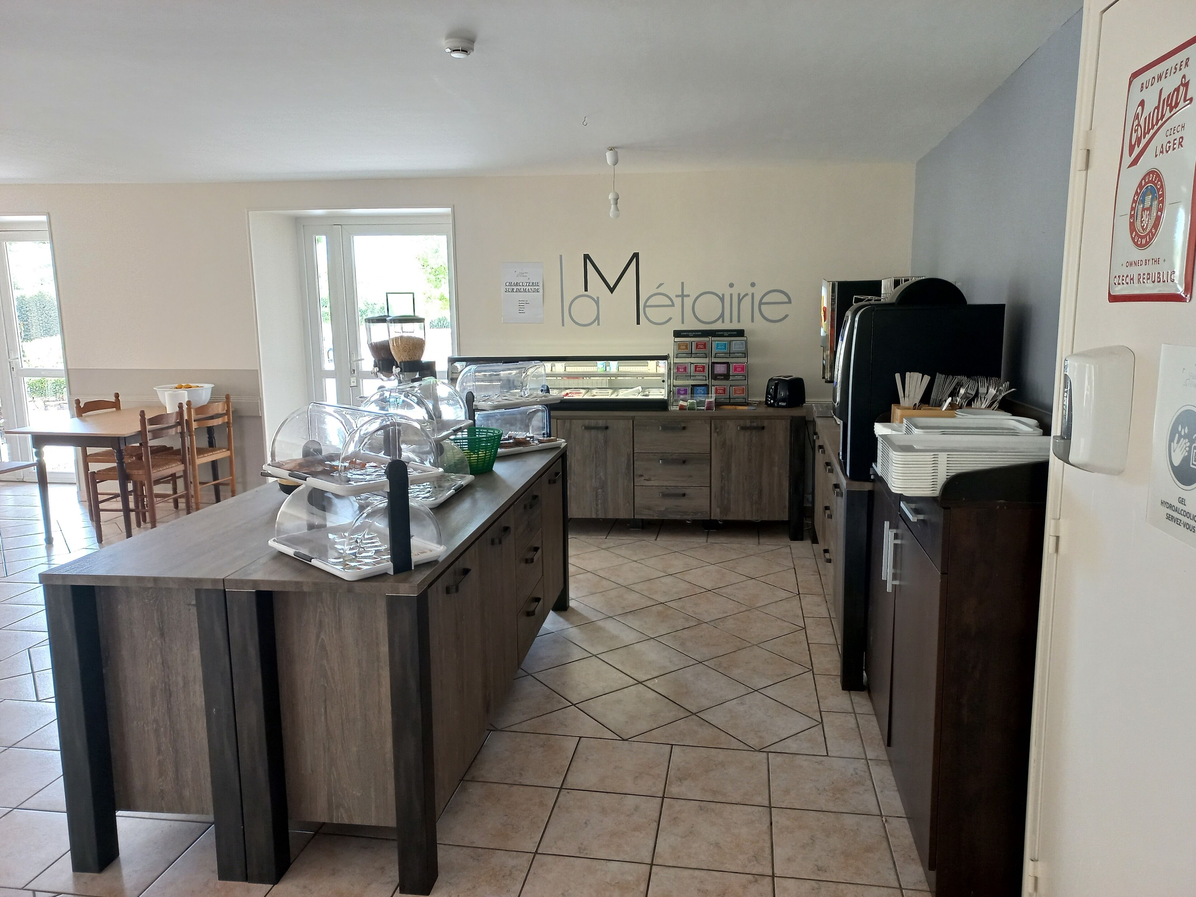 A modern kitchen with a central island, a coffee machine, and a refrigerator.