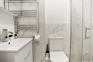 Apartamento | Banheiro | Chuveiro, secador de cabelo, toalhas de banho, shampoo