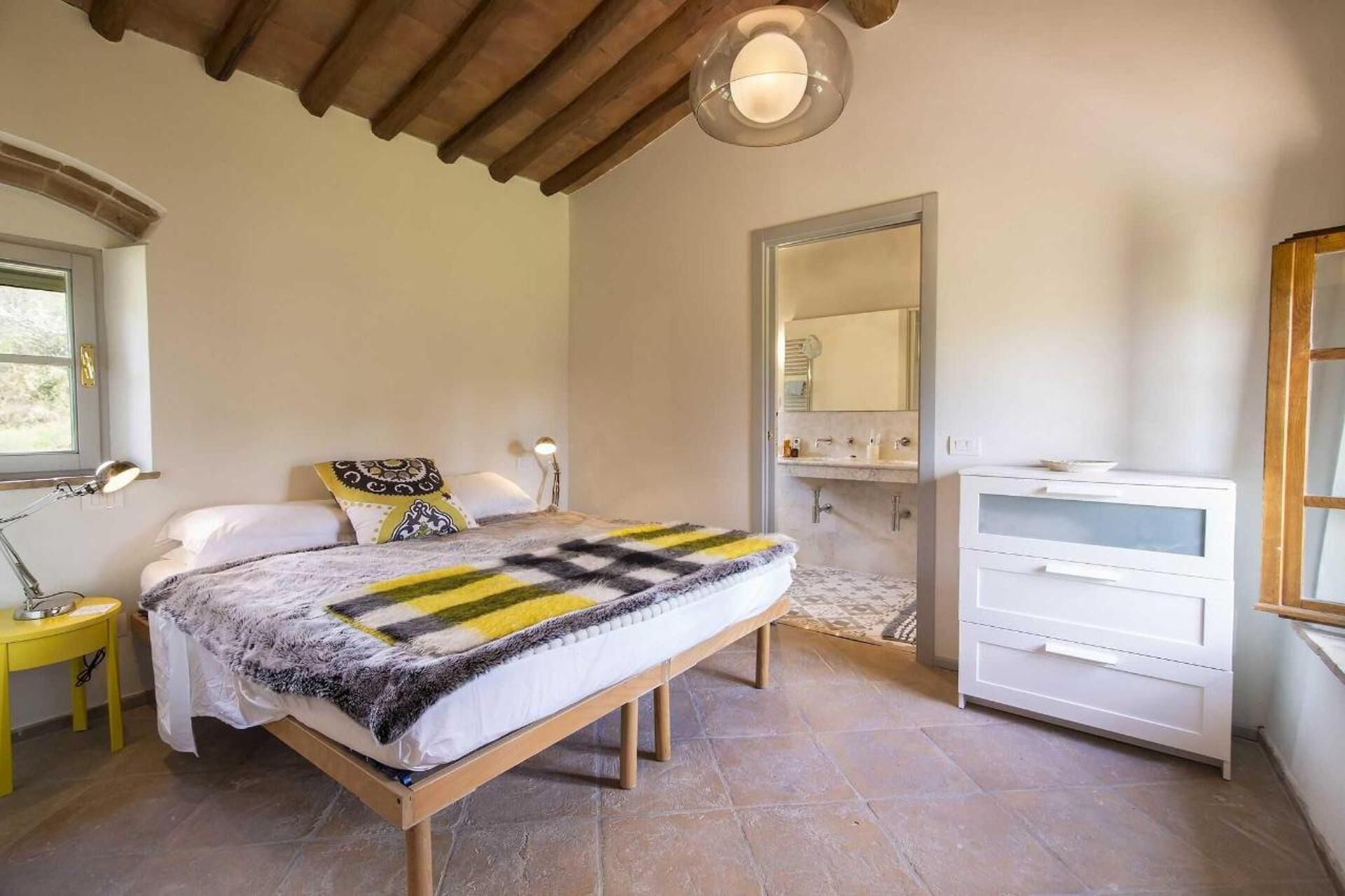 Una camera da letto con un letto, comodini, uno specchio e un comò.