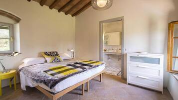 Una camera da letto con un letto, comodini, uno specchio e un comò.