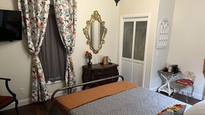 A neatly arranged bedroom with a bed, a bedside table, a mirror, a wardrobe, and a small table with a coffee maker. - Holland Farmhouse Inn B & B (Holland)