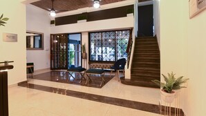 A spacious lobby with a high ceiling, a staircase, and seating areas. - PH 19 Guesthouse Hotel in Gazcue (Santo Domingo)