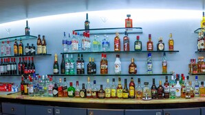 A bar with multiple shelves stocked with various bottles of liquor.