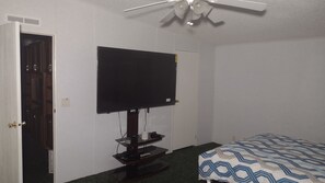 Cozy retreat with a single bed, flat-screen TV, and ceiling fan.