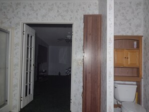 A bathroom with a toilet, a cabinet, and a shower area.