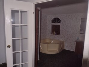 Relax in a spacious room with a bathtub and a small window above.