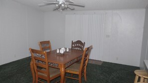 Enjoy meals in this cozy dining area with a wooden table and four comfortable chairs.