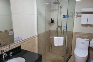 Bathroom features a glass-enclosed shower, sink, and toilet.