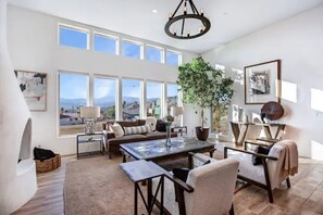Relax in a spacious living area with expansive views, a comfortable sofa set, and a potted plant.