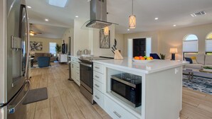 A modern kitchen with white cabinetry, a built-in oven, and a microwave. - VRCC Villa San Miguel (Cape Coral)