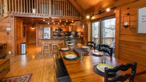 A spacious wooden cabin with a dining area, kitchen, and a balcony. - Cozy Cabin Tucked Away in Wooded Property (Boone)