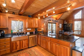 A spacious kitchen with wooden cabinets, a granite countertop, and a large island.
