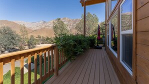 A wooden deck with a railing, large windows, and a view of a mountainous landscape. - Epic Mountain View. Luxury House on a Hill. River 10 min (Kernville)