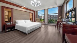 A hotel room with a large bed, a desk, a TV, and a view of the city. - Yifeng Hotel (Wenli College Honghe Campus Store) (Chongqing)