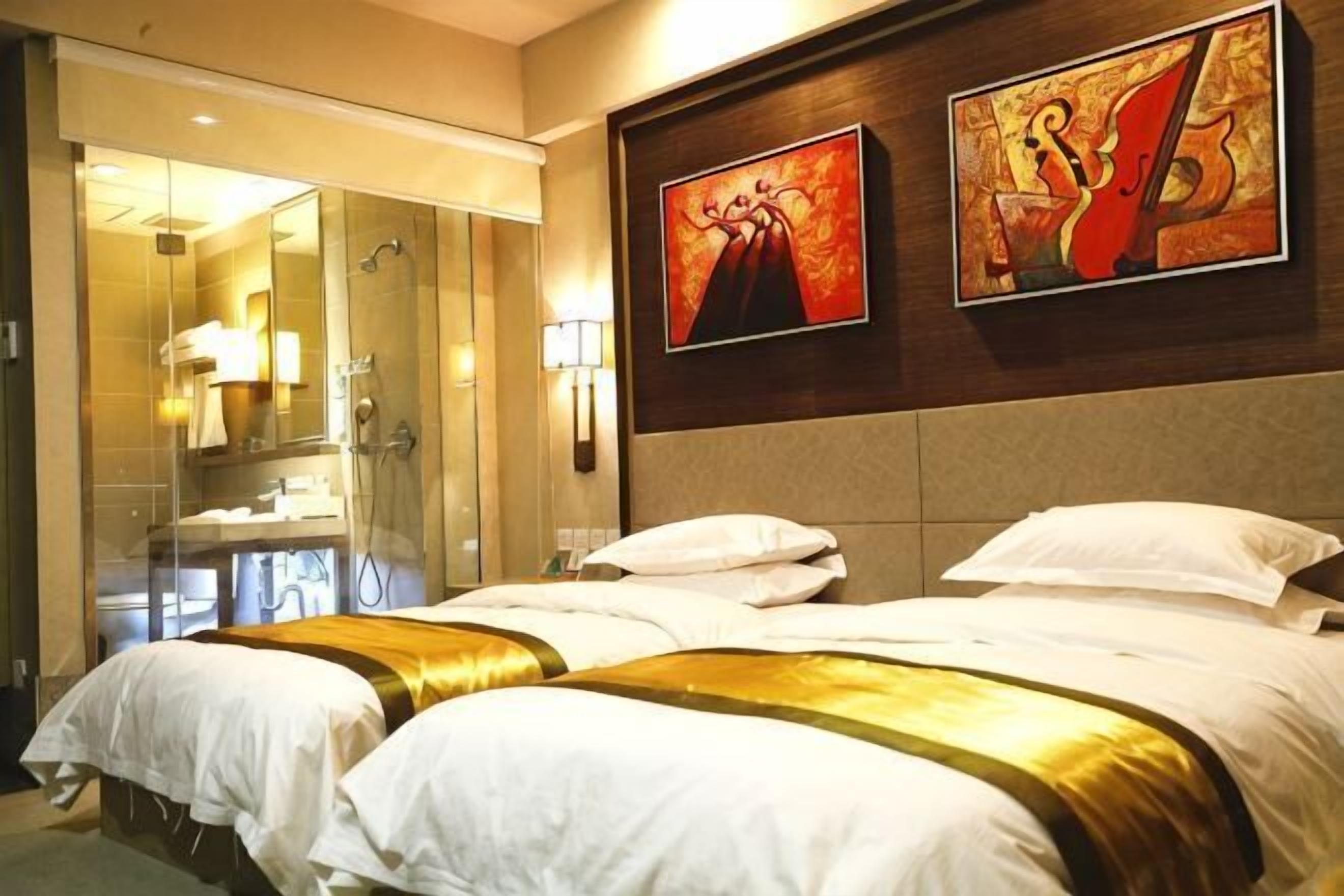 Habitación de hotel con dos camas, un espejo grande y obras de arte en la pared.