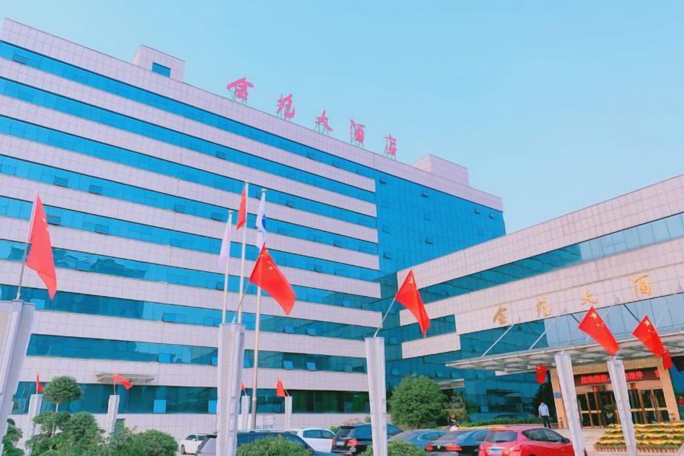 A modern building with multiple flags, large windows, and a clear sky.