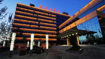 A modern hotel with a prominent entrance and multiple floors.