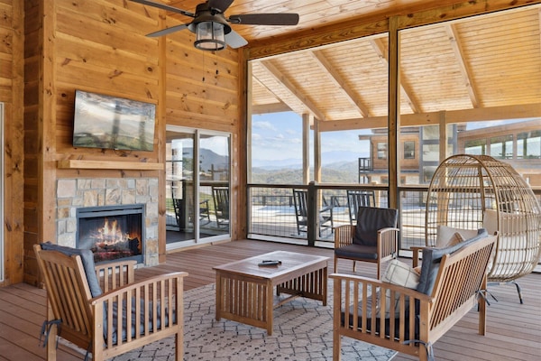 Enjoy the large screened in patio complete with 70" SmartTV, electric fireplace | Please Note: The fireplace has been slightly altered since this photo was taken. It remains an electric fireplace, however, design has been updated