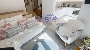 A modern living room with a sofa, a fluffy chair, and a small round table.
