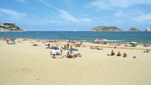A beach with people sunbathing and swimming, tents, and umbrellas. - Edificio Tamarius by Interhome (L'Estartit)