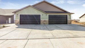 Een tweemaal bemeten garage, aangesloten bij een gebouw met een schuin dak en stenen details.