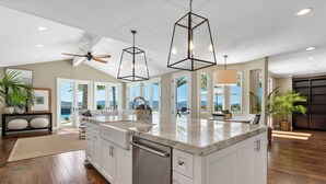 A spacious kitchen with a large island, white cabinetry, and a view of the outdoors. - Wine Country Retreat • Pool, Spa, Views (Temecula)