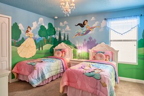 A bedroom with two beds, each with a Disney princess-themed bedspread, a mural of Disney princesses on the wall, and a chandelier. - Epic 9BR Game House - Arcade, PS5, Pool & Hot Tub (Davenport)