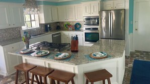 A kitchen with white cabinets, a stainless steel refrigerator, a built-in oven, and a granite countertop. - Waterfront, Boat Dock, Great Fishing - Long Term Renters Welcome - Sleeps 9 (Trinity)