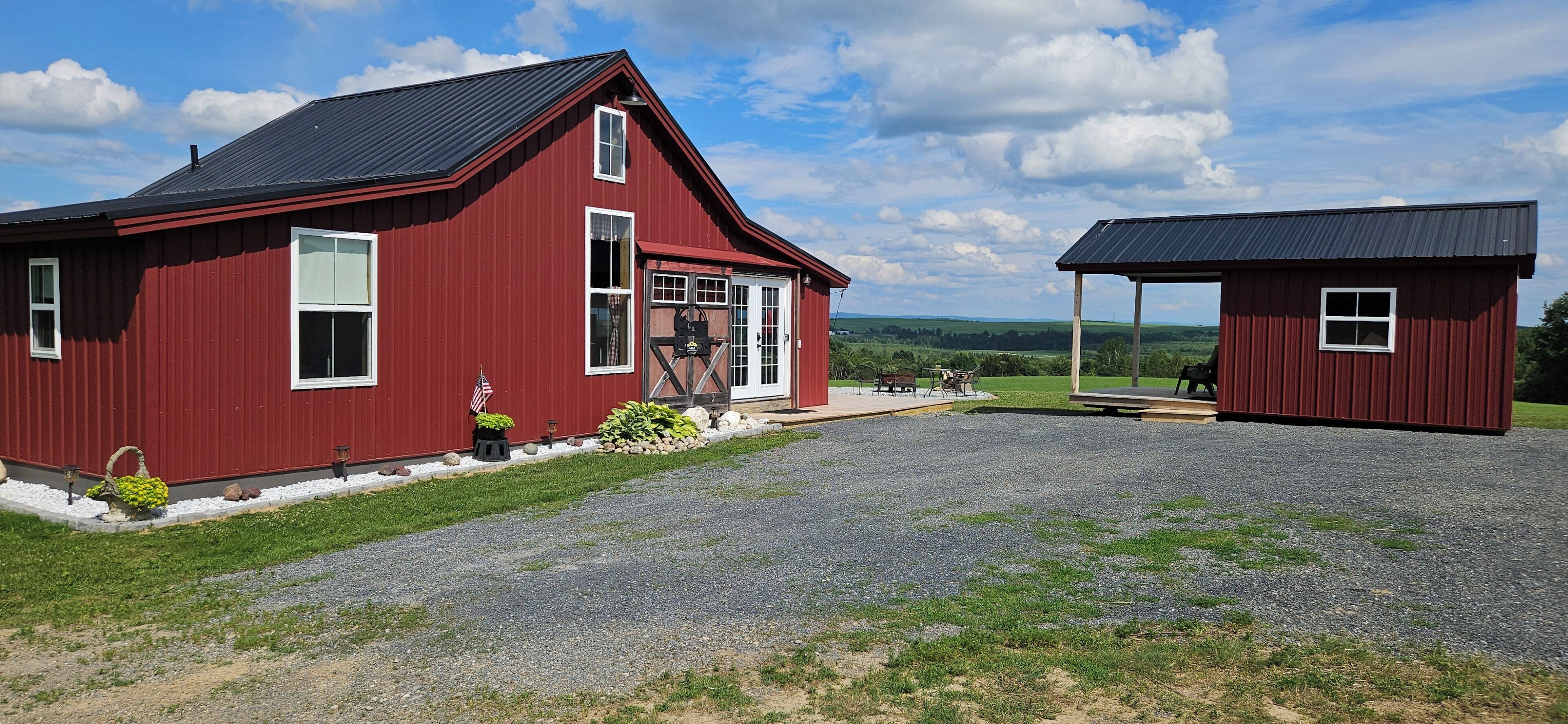 A red barn with a porch and a smaller attached structure.