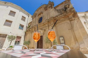 Una mesa con mantel a cuadros frente a un edificio histórico de arquitectura ornamentada.