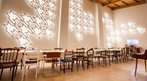 A restaurant interior with tables and chairs, wooden ceiling beams, and patterned wall lighting. - 200m historical center, private patio, ac, 8'drive to the beaches. (San Vito Dei Normanni)