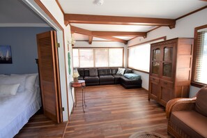 Ein Zimmer mit einem Bett, einem Schlafsofa, einem Schrank und einem Fenster mit Jalousien.