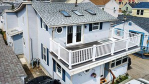 A two-story house with a balcony, a garage, and a driveway. - Beach Condo with a view! 3-bedroom with balcony porch! (Hampton)