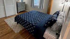 A bedroom with a bed, a dresser, a window with curtains, and a floor lamp. - Beach Condo with a view! 3-bedroom with balcony porch! (Hampton)