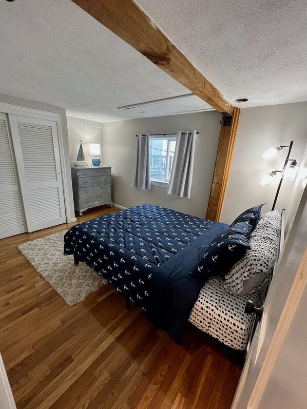 A bedroom with a bed, a dresser, a window with curtains, and a floor lamp. - Beach Condo with a view! 3-bedroom with balcony porch! (Hampton)