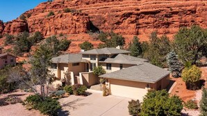 A residential area with houses surrounded by red rock formations.