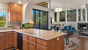 A modern kitchen with wooden cabinets, a granite countertop, and a built-in dishwasher. - Lux 2-King Suite Luxury Townhome! Pool + Hot Tub! (Sedona)