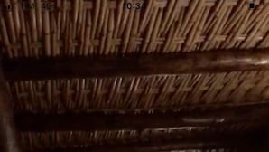 A dimly lit corridor with wooden beams and a rustic ceiling.