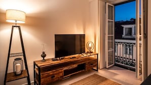 Ein gemütliches Wohnzimmer mit einer Holzeinrichtungsanlage, einem Flachbildfernseher, einer Stehlampe und einem dekorativen Kerzenständer.
