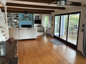 Relax in this inviting living room with a high ceiling, sofa, armchair, and TV.